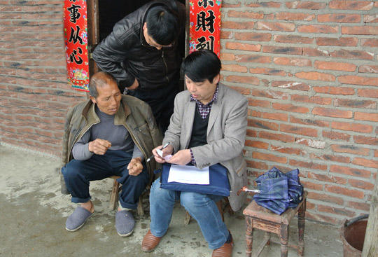 杨通和(右一)在兴仁镇卓佐村走访群众